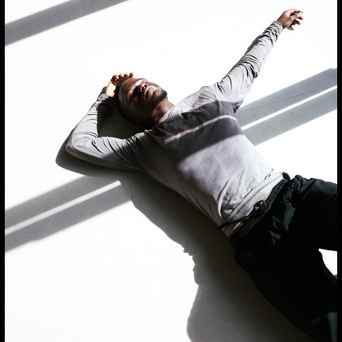 Assea lying in beams of sunlight with an arm outstretched